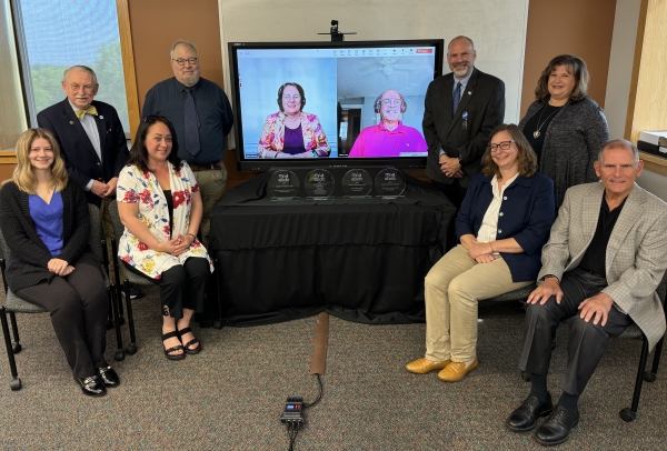 The OCC SBDC Staff (front row, left to right) is Jamie Procak, Keyona Kelly, Michele Baran, and Mark Pitonzo. Back row left to right: Paul Brooks, Neil Miller, Ph.D., Debbie Wilson and Michael Kinnie (in monitor), Bob Griffin, and Kelli Greene.