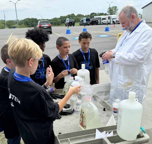 Professor Bob Collins (in white lab coat) helped students prepare their rockets for liftoff at Micron-sponsored Chip Camp.