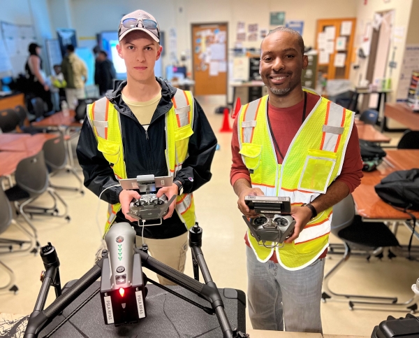 Quindell Williams '08 (right) teaches students how to fly drones at PSLA at Fowler in the Syracuse City School District.