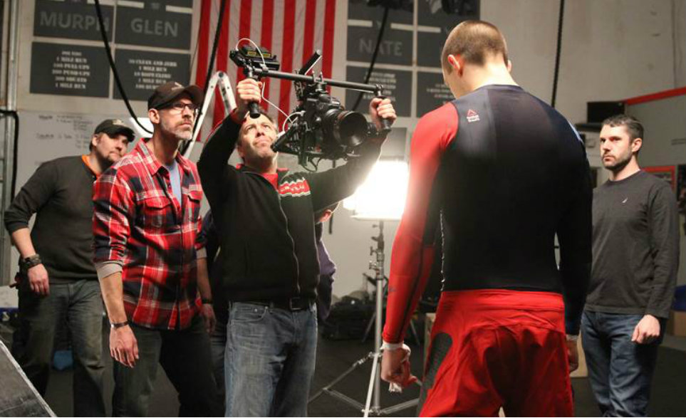 Melfi (holding camera) and business partner Evan Hathaway (left wearing plaid shirt) plan a shot while shooting a commercial for Reebok CrossFit.