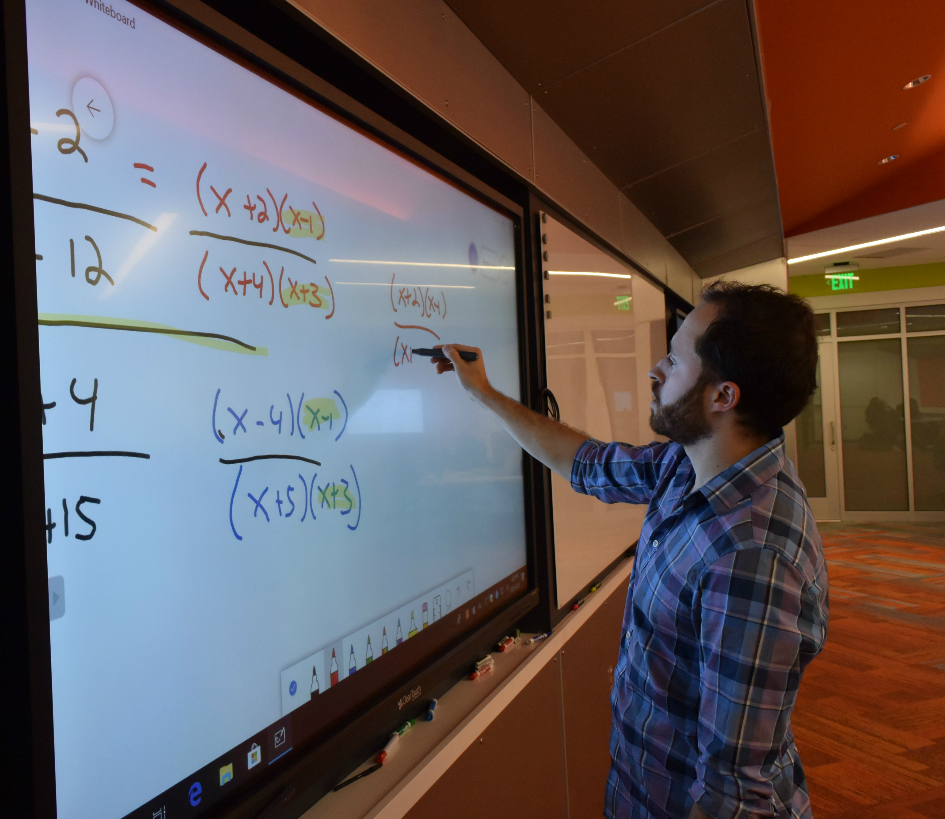 Professor Jason Furney writes out a math problem on a Microsoft Whiteboard in the new classroom in Ferrante Hall.