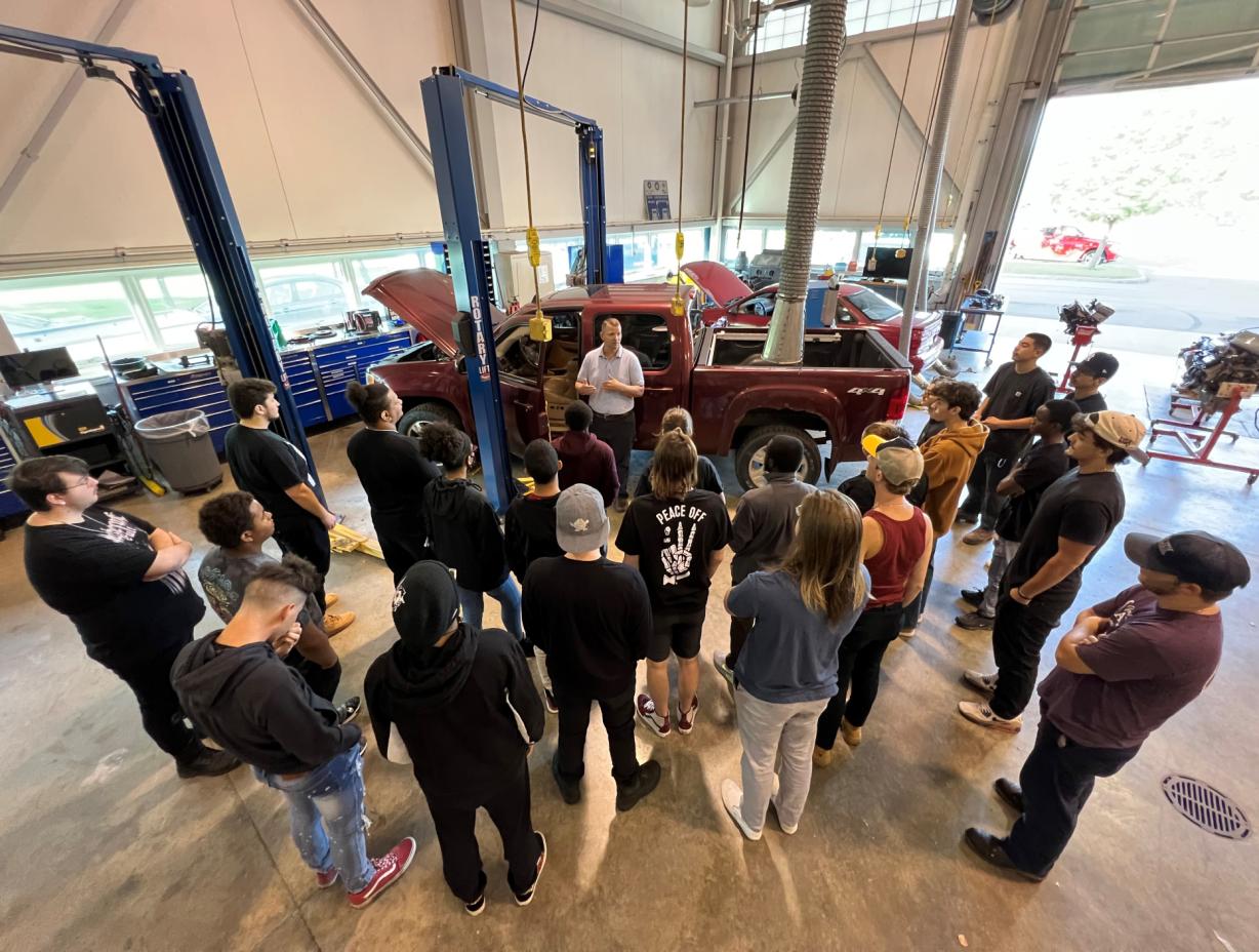 Professor Ryan Beckley (center, in gray shirt) speaks with students in the Automotive Technology lab in the Whitney Applied Technology Center. Professor Ryan Beckley (center, in gray shirt) speaks with students in the Automotive Technology lab in the Whitney Applied Technology Center.