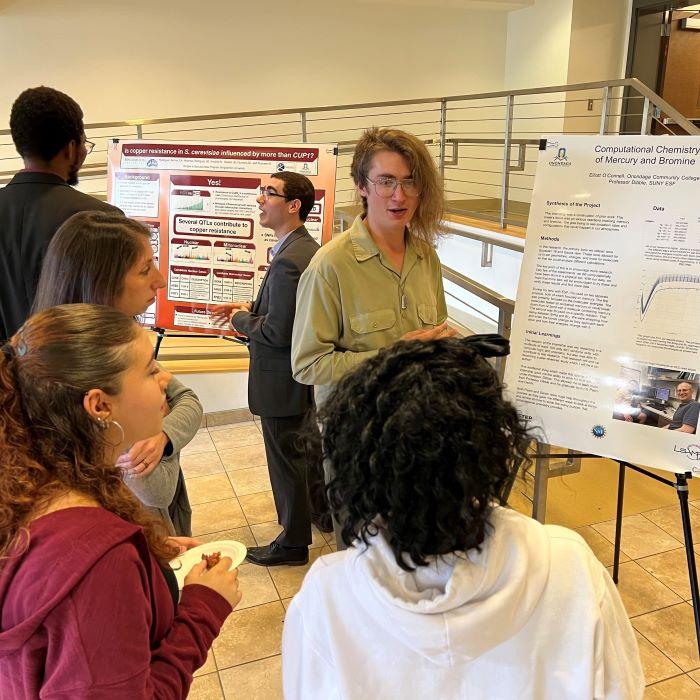 OCC students Carlos Rodriguez-Bornot (center left) and Elliott O'Connell (center right) discuss their summer research experiences during the Science Symposium. OCC students Carlos Rodriguez-Bornot (center left) and Elliott O'Connell (center right) discuss their summer research experiences during the Science Symposium.